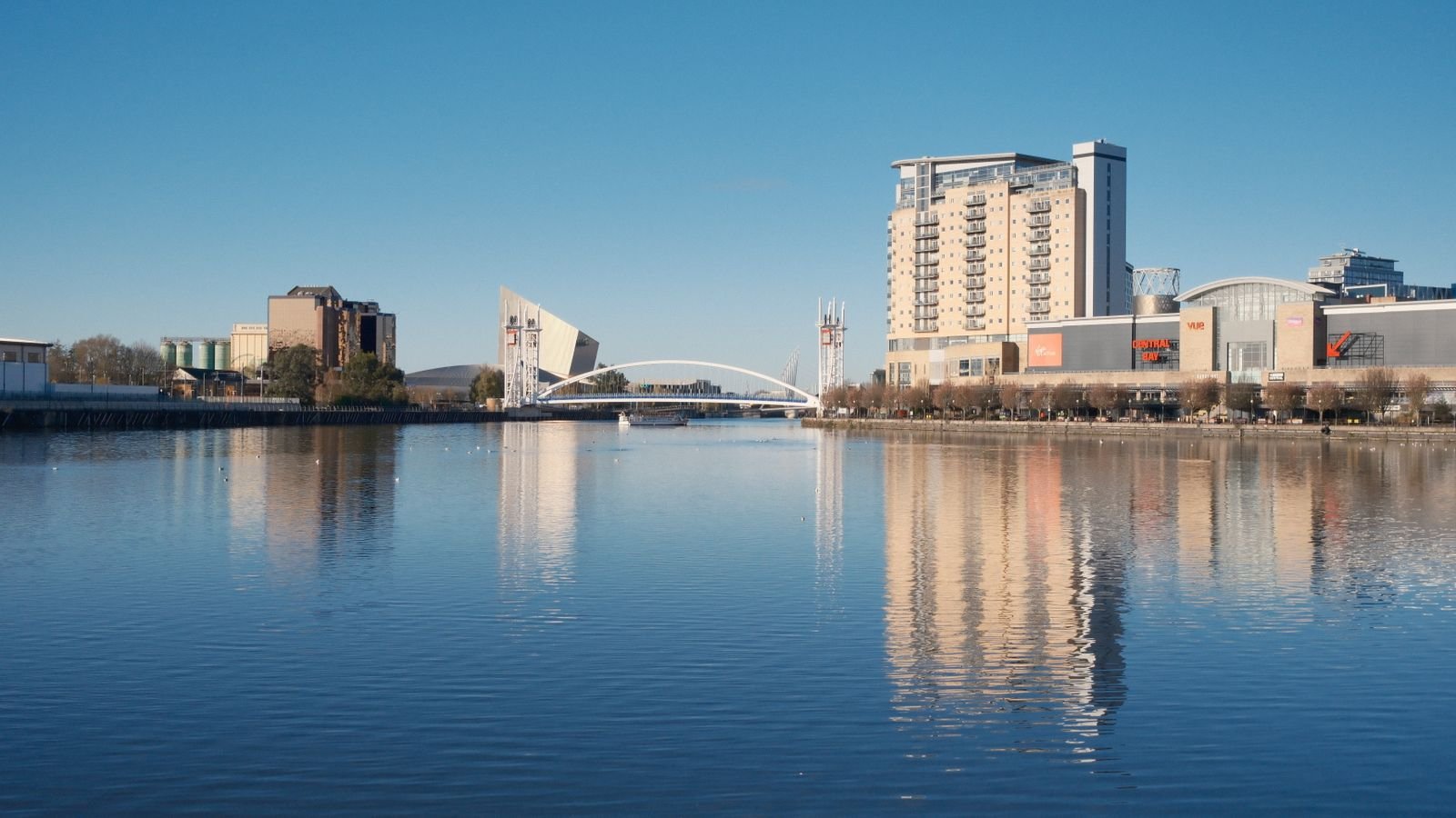 Riverside apartment buildings reflected in calm water, Dublin